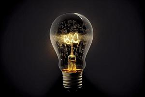 Sparkling light bulb on black background with ample copy space photo