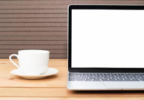 Coffee cup with laptop mockup on wood photo