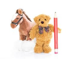 Teddy bear with red pencil and horses photo