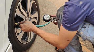 close up of driver checking the air pressure and filling the tires. concept of travel safety video