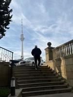 A man running up the stairs in front of the TV Tower. photo