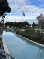 park with pool and azerbaijan flag waving in cloudy weather photo