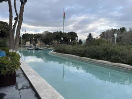 park with pool and azerbaijan flag waving in cloudy weather photo