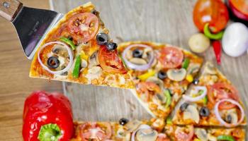 Popular colorful ingredients as like tomatoes, cheese, mushroom, capsicum, olives and other ingredients baked healthy Pizza. photo