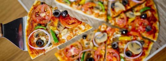 Popular colorful ingredients as like tomatoes, cheese, mushroom, capsicum, olives and other ingredients baked healthy Pizza. photo