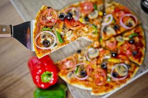 Popular colorful ingredients as like tomatoes, cheese, mushroom, capsicum, olives and other ingredients baked healthy Pizza. photo