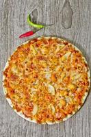 Classic Seafood Pizza with spicy chilli sauce. photo