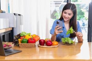 Diet, white-skinned young Asian woman in a blue shirt eating vegetable salad and apples as a healthy diet, opting for junk food. Female nutritionist losing weight. healthy eating concept. photo