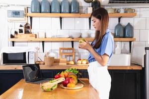 Diet, white-skinned young Asian woman in a blue shirt eating vegetable salad and apples as a healthy diet, opting for junk food. Female nutritionist losing weight. healthy eating concept. photo