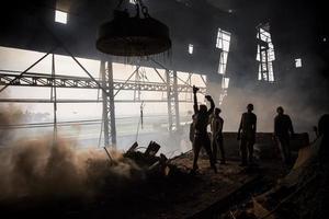 trabajadores fundir metal residuos en el horno de un acero molino a Produce varillas en demra, dhaka, bangladesh foto