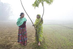 Bangladesh enero 06, 2014 en un brumoso invierno mañana, dos mujer son chismoso a ranisan kail, Thakurgaon. foto