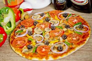 Popular colorful ingredients as like tomatoes, cheese, mushroom, capsicum, olives and other ingredients baked healthy Pizza. photo