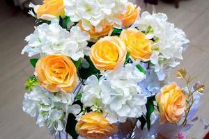 White and yellow artificial paper flowers vase. wedding decoration. Plastic colorful decorated rose flower. photo