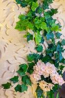 Plastic green leaf decorated wedding decor background. wedding decoration. Plastic colorful decorative leaves. photo