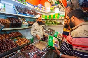 Bangladesh March 10, 2019 A seller of dried ripe dates is bargaining with his buyer in the store at Borobazar, Khulna, Bangladesh. photo