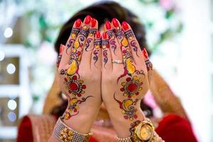 un novia cubre su cara con ambos manos. indio boda. foto