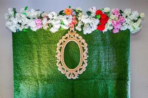 Green artificial grass based wedding stage with artificial colorful paper flower decoration. photo