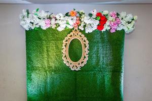 Green artificial grass based wedding stage with artificial colorful paper flower decoration. photo