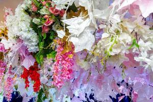 Colorful artificial paper flowers hanging on a stage. wedding decoration. Plastic colorful decorated flower. photo