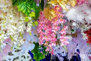 Colorful artificial paper flowers hanging on a stage. wedding decoration. Plastic colorful decorated flower. photo