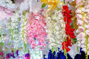 Colorful artificial paper flowers hanging on a stage. wedding decoration. Plastic colorful decorated flower. photo