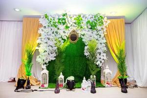 Green artificial grass based wedding stage with artificial colorful paper flower decoration. photo