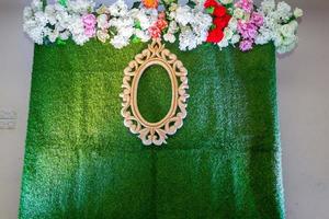 Green artificial grass based wedding stage with artificial colorful paper flower decoration. photo