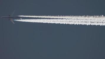 flygplan contrail i klar blå himmel. flygplan flygande över huvudet, lång skott video