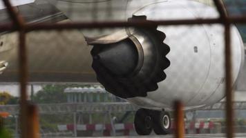 Jet engine of airplane. Aircraft view through airport fence. Plane on the runway preparing for takeoff video