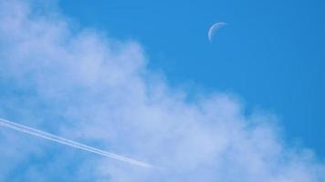 un avion mouches haute dans le bleu ciel et feuilles une blanc traînée derrière il video