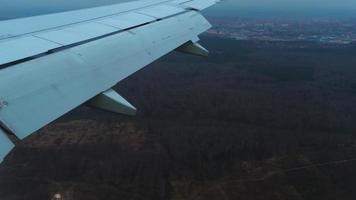 comercial aeronave acerca de a tierra. avión terminado el ciudad, ver desde el ventana. video