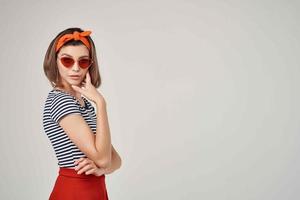 mujer en a rayas camiseta con vendaje en su cabeza vistiendo Gafas de sol Moda verano foto