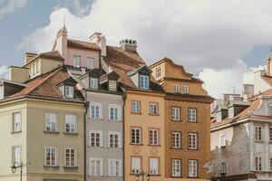 old historic tenement houses against the blue sky in the old town square in Warsaw, Poland photo