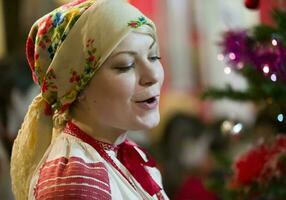 Slavic girl in a scarf sings a song. Belarusian woman. photo