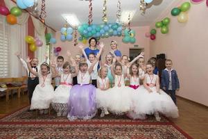 grupo de alegre niños en jardín de infancia a el graduación fiesta. foto