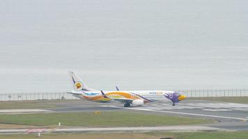 PHUKET, THAILAND NOVEMBER 28, 2017 - Boeing 737, HS DBY of Nok Air taxiing to the runway of Phuket airport. Airfield on the background of the sea. Tourism and travel concept video