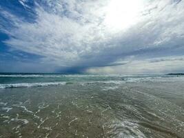 serene seaside landscape with sky with clouds and waves photo