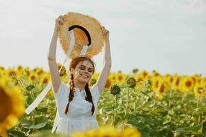 beautiful sweet girl in a white dress walking on a field of sunflowers Summer time photo