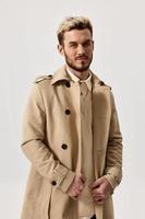 portrait of a blonde in a beige coat and a light background beautiful face trend of the season spring photo