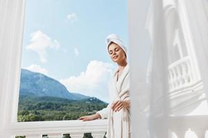 Portrait of gorgeous woman posing against the backdrop of mountains on the balcony architecture Relaxation concept photo
