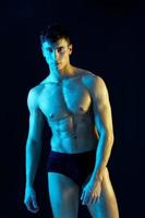 male athlete on a neon background model inflated torso blue yellow light model photo