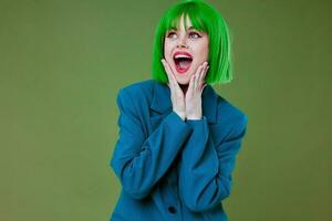 Beautiful fashionable girl fun gesture hands green hair fashion green background unaltered photo