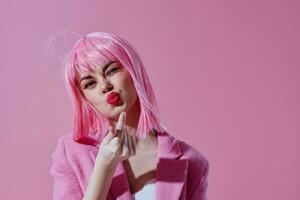 Young woman pink jacket holding hair cosmetics pink background unaltered photo