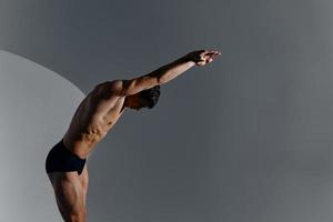 bodybuilder man with a pumped-up torso and with raised arms leaned forward photo