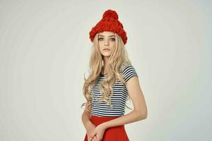 bonito mujer en de moda ropa rojo sombrero ligero antecedentes foto
