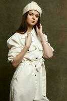 beautiful woman in jumpsuit cap on brown background posing in a photo studio