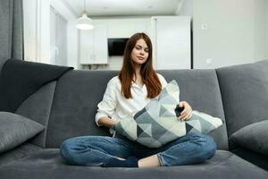 woman sitting on the couch in her free time with a pillow in her hands rest apartment interior photo