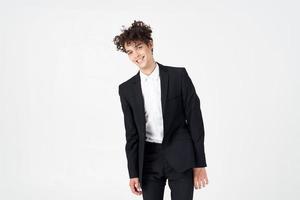 young guy in a classic suit on a light background curly hair portrait cropped view photo