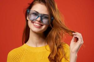 cheerful attractive woman holding hair glasses fashion studio photo