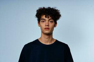 man with curly hair in black t-shirt cropped view isolated background photo